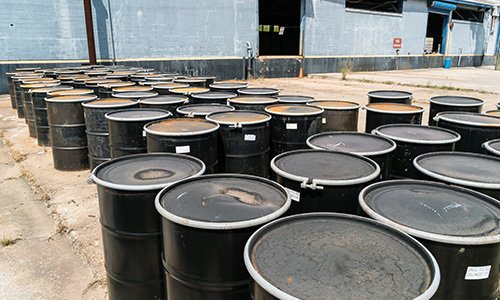 rows of black drums outside a building